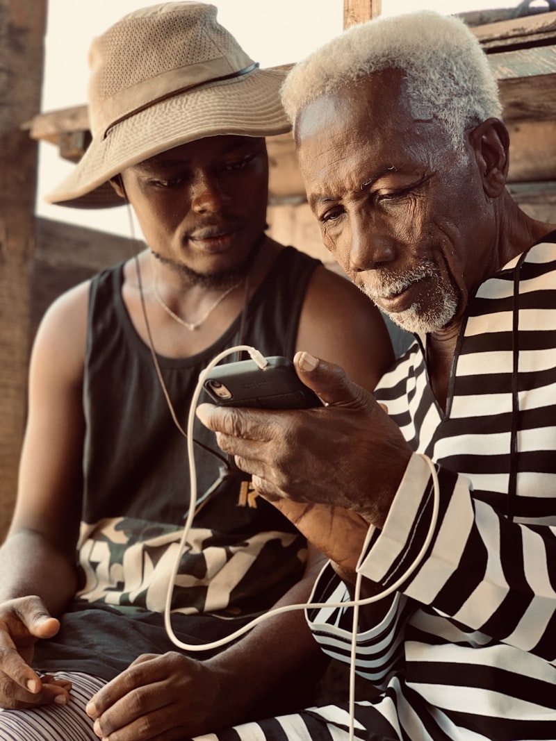 Elder and young man looking at a phone together