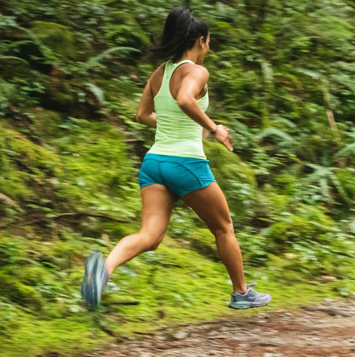 A woman running on a forest trail