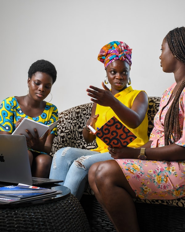 A team collaborating over a laptop on a couch